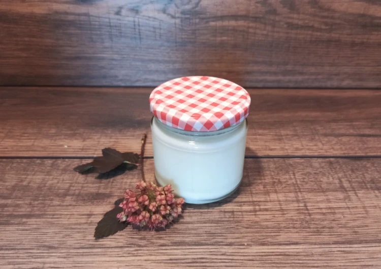 Jogurt kozi naturalny 160 ml Yagi – słoiczek z jogurtem kozim ustawiony na drewnianym tle, naturalny produkt bez dodatków w rustykalnym stylu.