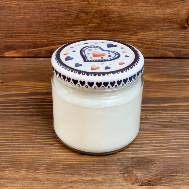 Jogurt kozi naturalny 160 ml Yagi – słoiczek z jogurtem kozim ustawiony na drewnianym tle, naturalny produkt bez dodatków w rustykalnym stylu.