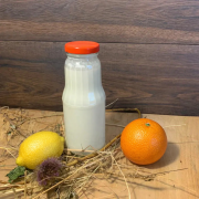 Kefir kozi na grzybku tybetańskim ze skórką cytrusową BIO w szklanej butelce, na rustykalnym drewnianym tle. Naturalny produkt z koziego mleka z Gospodarstwa Yagi.